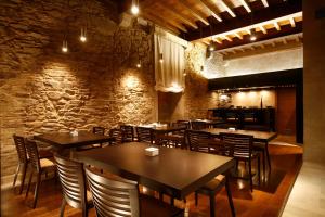 ein Restaurant mit Tischen und Stühlen und einer Steinmauer in der Unterkunft Hotel Altaïr in Santiago de Compostela
