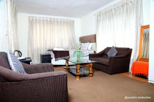 a living room with two chairs and a coffee table at Harmony Guest House in Johannesburg