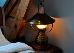a lamp sitting on a table next to a bed at Villa Kakelbont in Leeuwarden