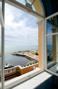 a window with a view of the beach and ocean at GH Palazzo Suite & SPA in Livorno