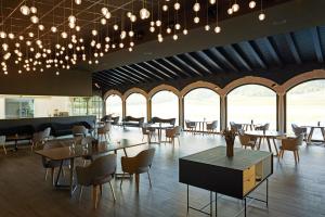 ein Restaurant mit Tischen und Stühlen und großen Fenstern in der Unterkunft Hotel & Spa Arzuaga in Quintanilla de Onésimo
