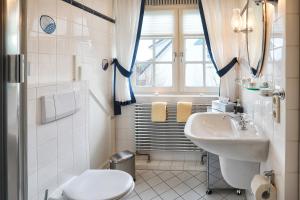 Baño blanco con lavabo y aseo en Heefwai 2 W6, en Morsum