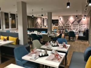 un restaurante con mesas y sillas y un comedor en Mercure Hotel Kaiserhof City Center en Frankfurt