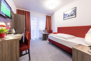 a hotel room with a bed and a desk at Hotel Himalaya Frankfurt City Messe in Frankfurt/Main