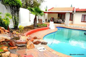 a swimming pool in a yard next to a house at Harmony Guest House in Johannesburg