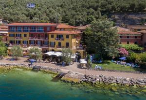 a group of buildings next to a body of water at Hotel Residence Villa Beatrice in Brenzone sul Garda