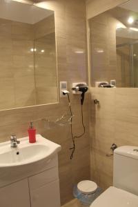 a bathroom with a sink and a toilet and a mirror at Hotel Polonia in Namysłów