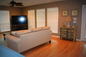 a living room with a couch and a flat screen tv at 1 Coastal Calm Home in Bolivar Peninsula