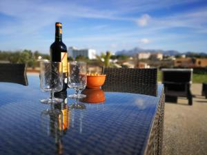 una botella de vino sentada en una mesa con copas en Ses Roques, en Alcudia