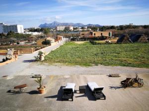 a parking lot with chairs and a field with mountains at Ses Roques in Alcudia