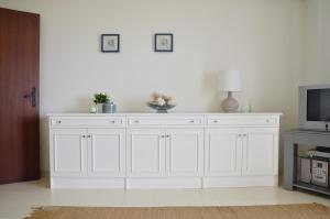 a white cabinet in a living room with a tv at Baleal Tower Bay Apartment in Ferrel