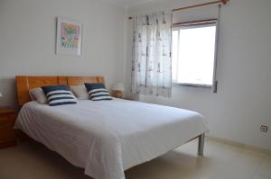a bedroom with a bed with blue and white pillows at Baleal Tower Bay Apartment in Ferrel