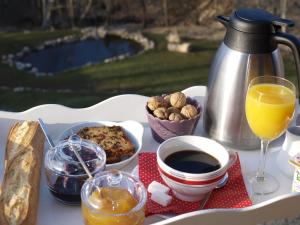 einen Tisch mit einem Tablett mit Essen und einer Tasse Kaffee in der Unterkunft Au Chant du Riou in Saint-Michel-de-Chaillol