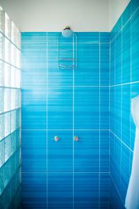 baño de azulejos azules con ducha de azulejos azules en Villa al Fe en Los Órganos