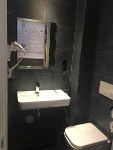 a bathroom with a sink and a toilet at Hotel Manofa in Amsterdam