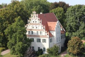 ein großes weißes Haus mit einem roten Dach in der Unterkunft Ferienwohnung Schlossblick Altenburg in Altenburg