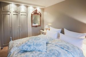 a bedroom with a blue and white bed and a mirror at Sönshorn 8 Mitte in Munkmarsch