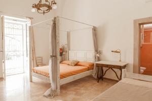 a bedroom with a canopy bed and a table at Agriturismo Li Calizzi Arte e Natura in Novoli +77 photos