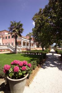 una casa grande con flores rosas en un patio en Villa Santa Barbara, en Montefalco