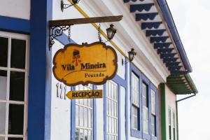 een teken voor een vita minerva polijst die buiten een gebouw hangt bij Pousada Vila Mineira in Lavras Novas