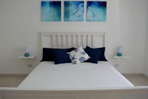 サンタニェッロにあるPuesta del Sol - Home Holdaysの白いベッド(青い枕付)が備わるベッドルームです。