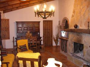 Casa Rural La Herradura في أنتيكيرا: غرفة معيشة مع موقد وغرفة طعام