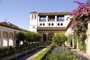 un jardín frente a un edificio con flores púrpuras en Penthouse "Art4you" en Mojácar