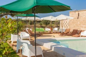a group of chairs and umbrellas next to a pool at Agriturismo Li Calizzi Arte e Natura in Novoli