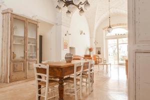 a dining room with a wooden table and chairs at Agriturismo Li Calizzi Arte e Natura in Novoli