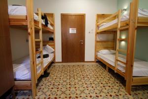 a room with three bunk beds and a door at Corner Hostel in Sliema