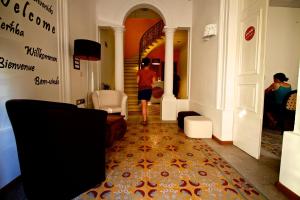 a person walking down a hallway in a building at Corner Hostel in Sliema