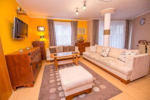 Una sala de estar con un sofá y un televisor. en Apartement DeLux Port, en Kołobrzeg