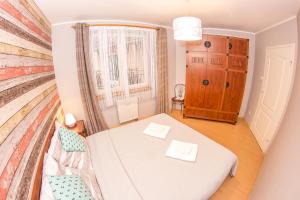 Una pequeña habitación con una cama y una ventana. en Apartement DeLux Port, en Kołobrzeg