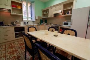 a kitchen with a table and chairs and a refrigerator at Corner Hostel in Sliema