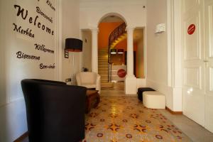 a hallway with a living room with a couch and chairs at Corner Hostel in Sliema