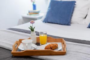 a tray with a cup of orange juice and a plate of food at Maiv Apartments in Rogoznica