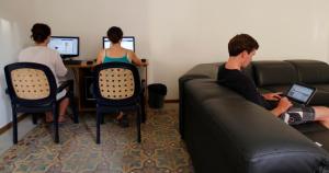 a group of people sitting on chairs in front of computers at Corner Hostel in Sliema