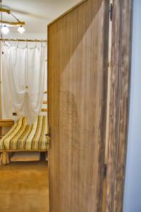 Habitación con tabique de madera, cama y cortina en B&B Wild Sardinia, en Domusnovas