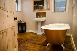 a bathroom with a large tub and a sink at The Carrick in Portrush +37 photos