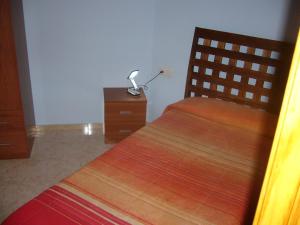 a bedroom with a bed and a lamp on a dresser at Piso en calle Campo in Tomelloso