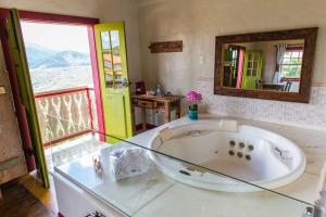 a large bathroom with a tub and a mirror at Pousada Vila Mineira in Lavras Novas