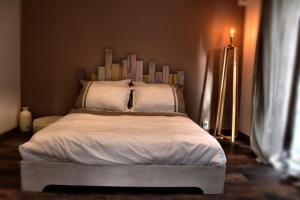 een slaapkamer met een groot bed met witte lakens en kussens bij Chez Les Filles - Bungalodge in Petite Île