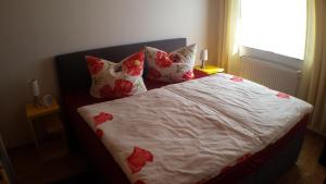 a bedroom with a bed with red flowers on it at Ferienwohnung Katzenberger in Beverungen