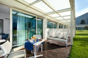 a screened in patio with a couch and a table at Seven Park Hotel Lake Como - Adults Only in Colico
