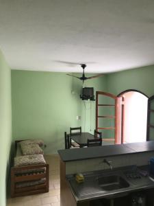 a kitchen with a sink and a chair in a room at Chalés Beto Amá in Ubatuba