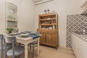 a dining room with a table and chairs and a cabinet at Spazio Duomo1 by Welc(H)ome in Treviso