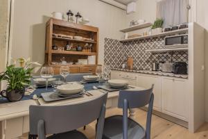 a dining room with a table and chairs and a kitchen at Spazio Duomo1 by Welc(H)ome in Treviso