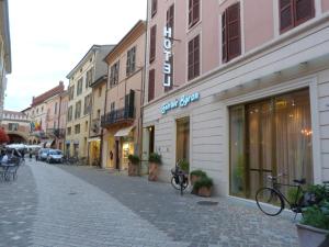 a city street with a bicycle parked in front of a building at Hotel Centrale Byron in Ravenna