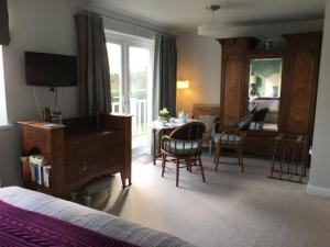 Schlafzimmer mit einem Bett, einem Tisch und Stühlen in der Unterkunft Gower View Luxury Bed & Breakfast in Tenby