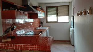 a kitchen with red tile walls and a refrigerator at Apartamento en 1ª LINEA Playa de Gandia in Gandía